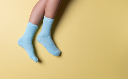 Child wearing socks over blue yellow color backgroundの写真素材
