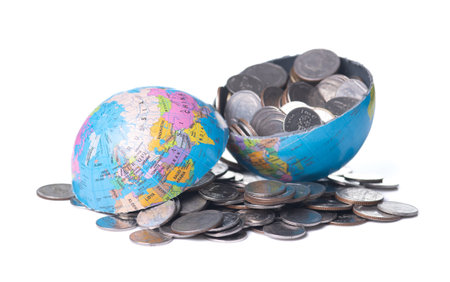 Globe cracking open with coins spilling out, Global economy conceptの写真素材