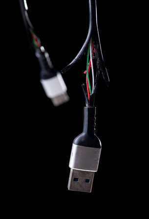 Broken black usb cable on dark background. old wire with dust.の写真素材