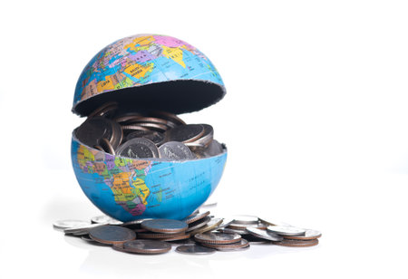 Globe cracking open with coins spilling out, Global economy conceptの写真素材
