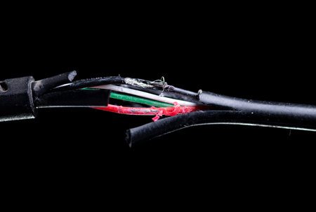 Broken black usb cable on dark background. old wire with dust.の写真素材
