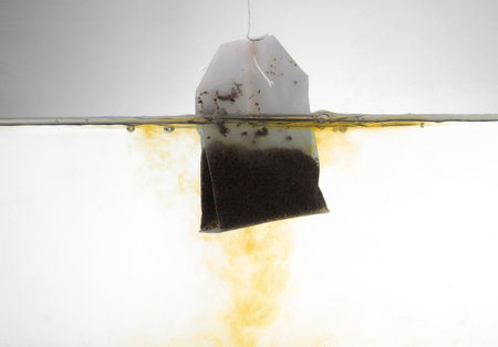 Tea bag soaking in transparent waterの写真素材