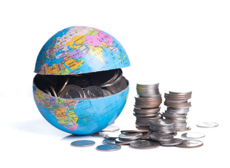 Globe cracking open with coins spilling out, Global economy conceptの写真素材
