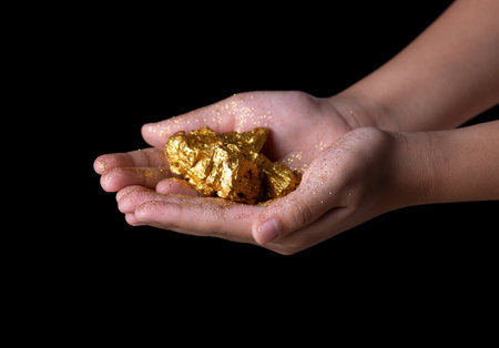 Gold nugget or gold ore in hand on black background.