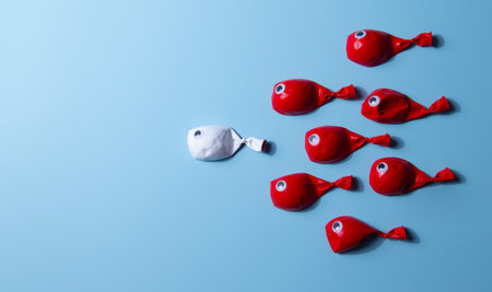 Leadership concept. white leader fish balloons leading red fish on blue background.の写真素材