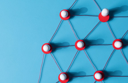 Wooden human figures connected by glowing thread â HR network and team connectivity on blue Backgroundの写真素材