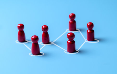 Wooden human figures connected by glowing thread â HR network and team connectivity
 on blue Backgroundの写真素材