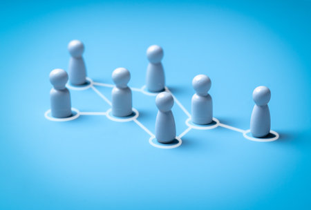 Wooden human figures connected by glowing thread â HR network and team connectivity on blue Backgroundの写真素材