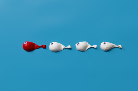 Different business concept.new ideas.Leadership concept with red fish balloon leading among white fishの写真素材