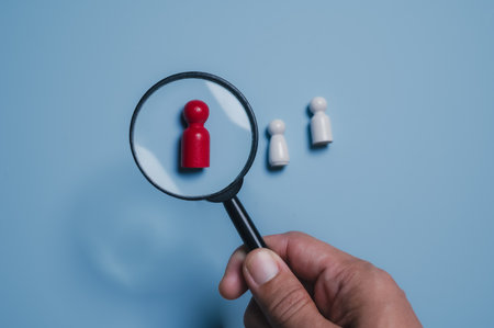 Human resources concept. Looking at red figure through magnifying glassの写真素材