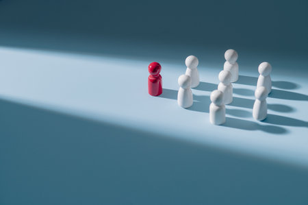 Red wooden figures stand out from the crowd of wooden figures. Leadership conceptの写真素材