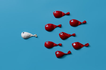 Different business concept.new ideas.Leadership concept with white fish balloons leading among red fishの写真素材