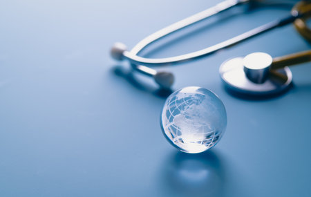 Glass global and stethoscope on light blue background, earth day, world health day, medical and healthcare business technology conceptの写真素材