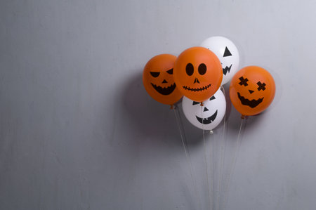 Orange and white balloons for Halloween party on gray background. Space for textの写真素材