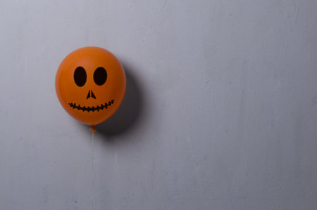 Orange balloon for Halloween party on gray background. Space for textの写真素材