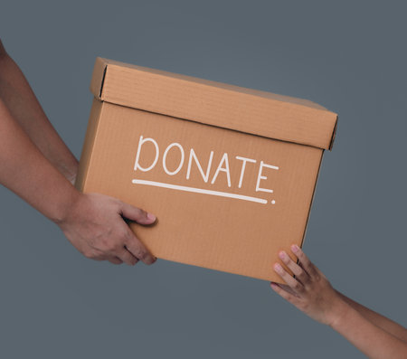 Donation Concept.hands giving a donation cardboard box