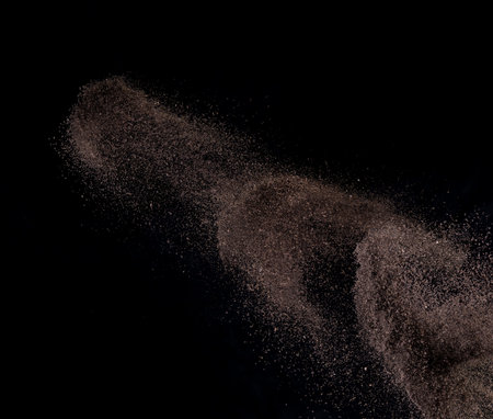 Dark Soil or Dust Particles Exploding on Black Background