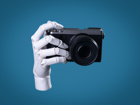 Robot Hand Holding a Digital Camera: AI Vision, Technology, and Future Photography Conceptの写真素材