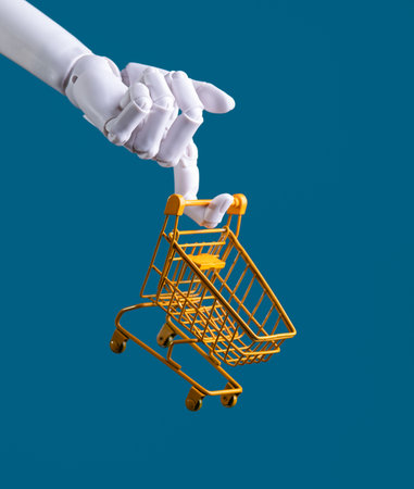 Robot Hand Holding a Miniature Shopping Cart: AI E-commerce, Automation, and Retail Conceptの写真素材