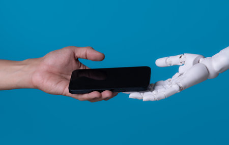 The Digital Transfer: Human and Robot Exchange a Smartphoneの写真素材