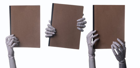 Robot Hands Presenting a Blank Brown Study Notebook on White Backgroundの写真素材