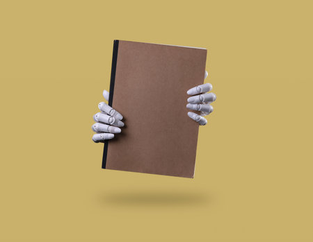 Robot Hands Holding a Blank Brown Notebookの写真素材