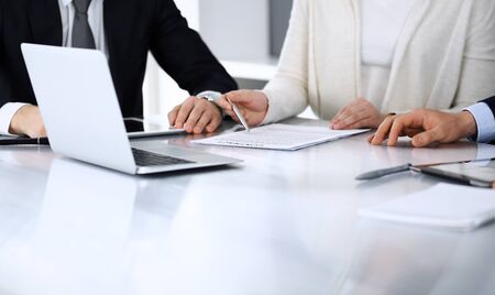 Business people discussing contract working together at meeting at the glass desk in modern office. Unknown businessman and woman with colleagues or lawyers at negotiation. Teamwork and partnership concept.の写真素材