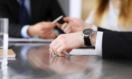 Business people discussing data questions at meeting in modern office. Unknown businessman and woman with colleague sitting and working at the glass desk. Teamwork and partnership concept.の写真素材
