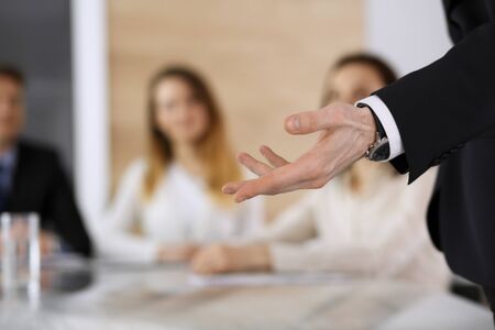 Business presentation. Businessman giving speech to colleagues and partners at corporate meeting or...