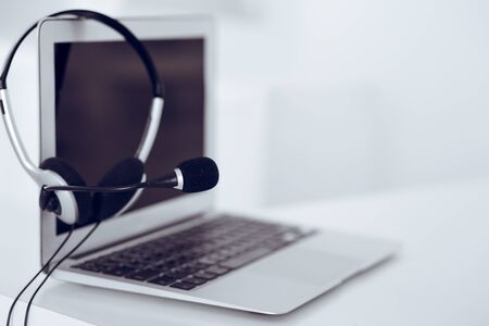 Call center and communication support, customer service help desk. VOIP headset on laptop computerの写真素材