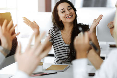 Group of business people discussing questions at meeting. Portrait of casual dressed businesswoman...