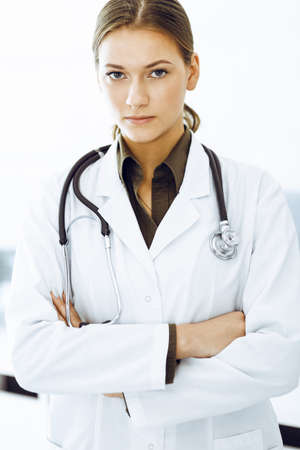 Woman-doctor standing with arms crossed and looking at camera. Medicine and healthcareの写真素材