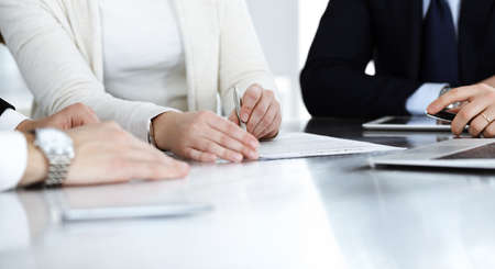 Business people discussing contract working together at meeting in modern office. Unknown businessman and woman with colleagues or lawyers at negotiationの写真素材