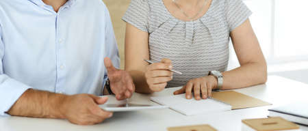 Unknown businessman and woman working with computer in a modern office, close-up. Group of diverse...
