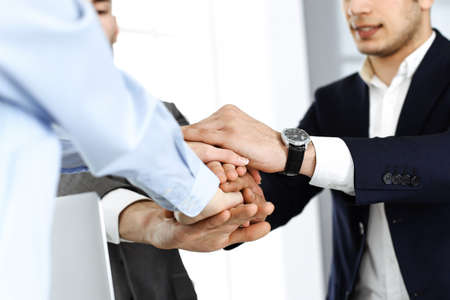 Business people group showing teamwork and joining hands as a circle in modern office. Success...