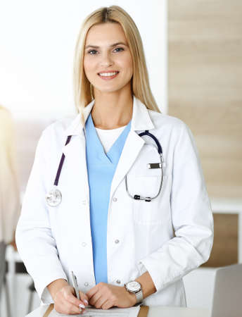 Doctor woman controls medication history records and exam results while using clipboard in sunny hospital . Medicine and healthcare conceptの写真素材