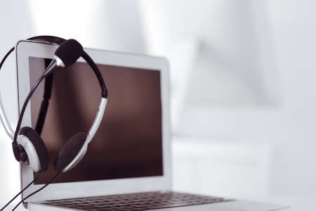 Call center and communication support, customer service help desk. VOIP headset on laptop computerの写真素材