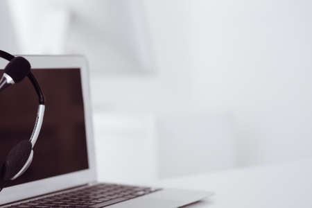 Call center and communication support, customer service help desk. VOIP headset on laptop computerの写真素材