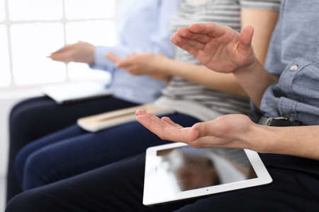 Business people clapping at meeting or conference, close-up of hands. Group of unknown businessmen and women in modern white office. Success teamwork, corporate coaching and applause conceptの写真素材