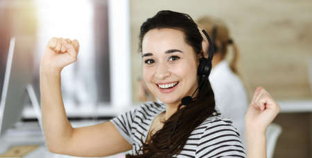 Business woman using headset for communication and consulting people at customer service office. Call center. Casual dress styleの写真素材