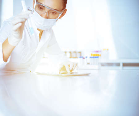 Female laboratory assistant analyzing test tube with blue liquid. Medicine, health care and researching conceptの写真素材