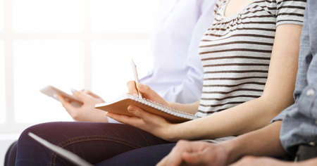Group of casual dressed business people working at meeting or conference in sunny office, close-up...