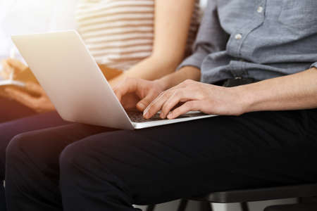 Group of casual dressed business people working at meeting or conference in sunny office, close-up...