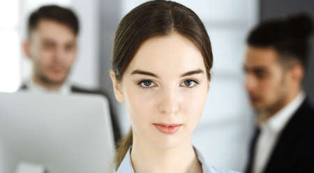 Business woman and group of diverse business people at the background in modern office. Multi ethnic teamwork and business conceptの写真素材