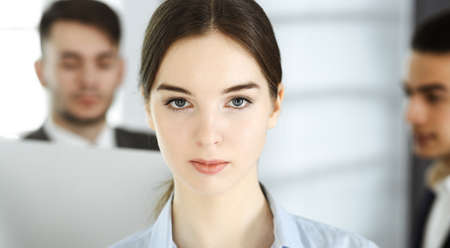 Business woman and group of diverse business people at the background in modern office. Multi ethnic...