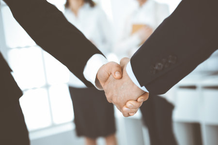 Businessman and woman shaking hands in office. Concept of handshake as success symbol in businessの写真素材