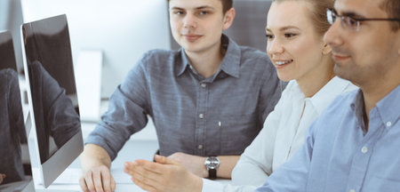 Business people working together in modern office. Happy smiling adult businessman using pc computer...