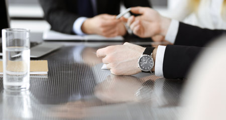 Unknown business people discussing questions of contract at meeting in modern office, close-up. Teamwork and partnership conceptの写真素材
