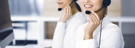 Unknown female customer service representative is consulting clients online using headset.close-up. Call center and business conceptの写真素材