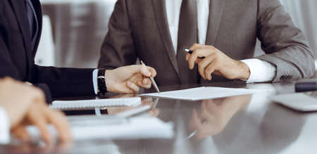 Unknown business people working together at meeting in modern office, close-up. Businessman and...